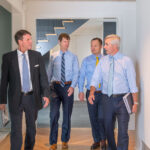 A group of men walking down a hallway.